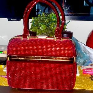 Bejeweled purse can be hand carried or carried by the shoulder strap